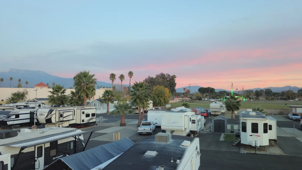 Person standing at open RV door looking at California mountains at golden hour peaceful new beginning